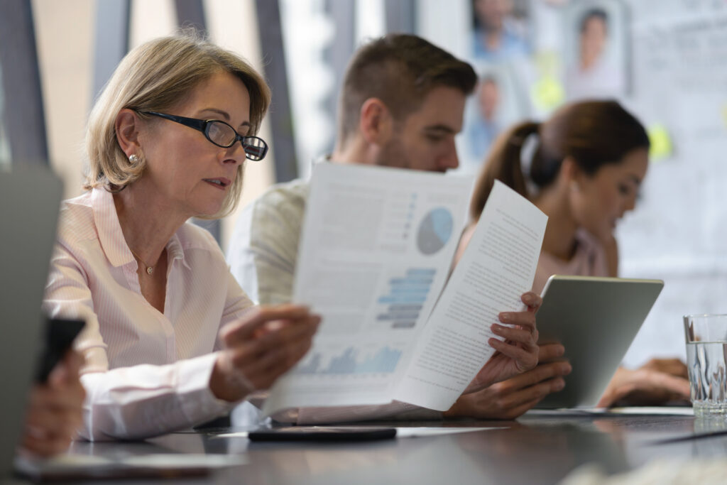 Photo of a female professional reading during a meeting.